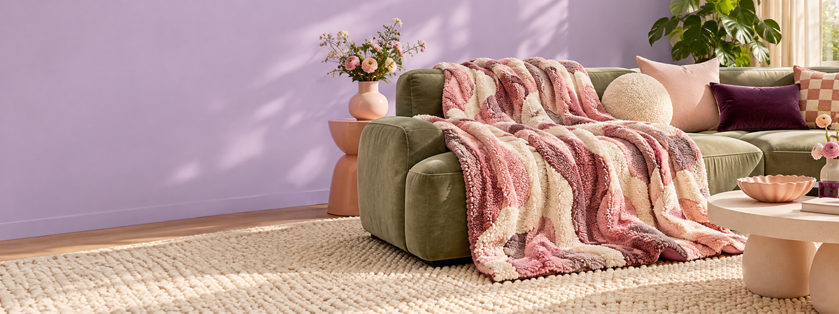 Brenura pink and cream textured throw styled on a sage sofa